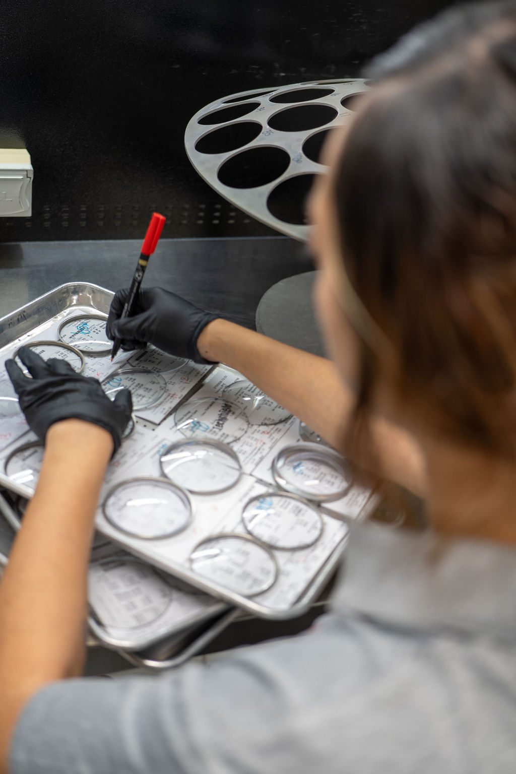 Lab technician marking lens trays before surfacing