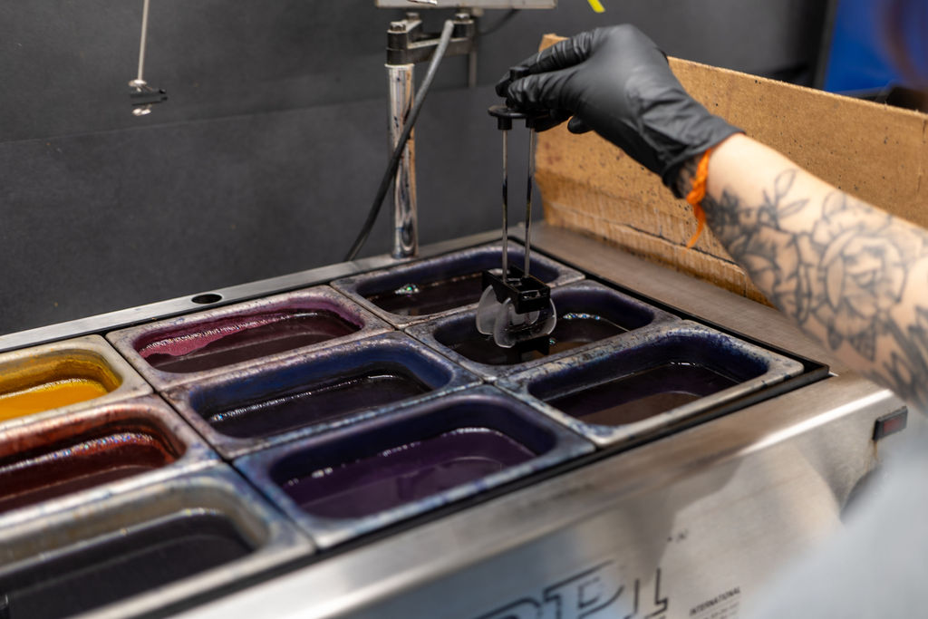 Hand-dyeing a lens in the lab's color tint vats
