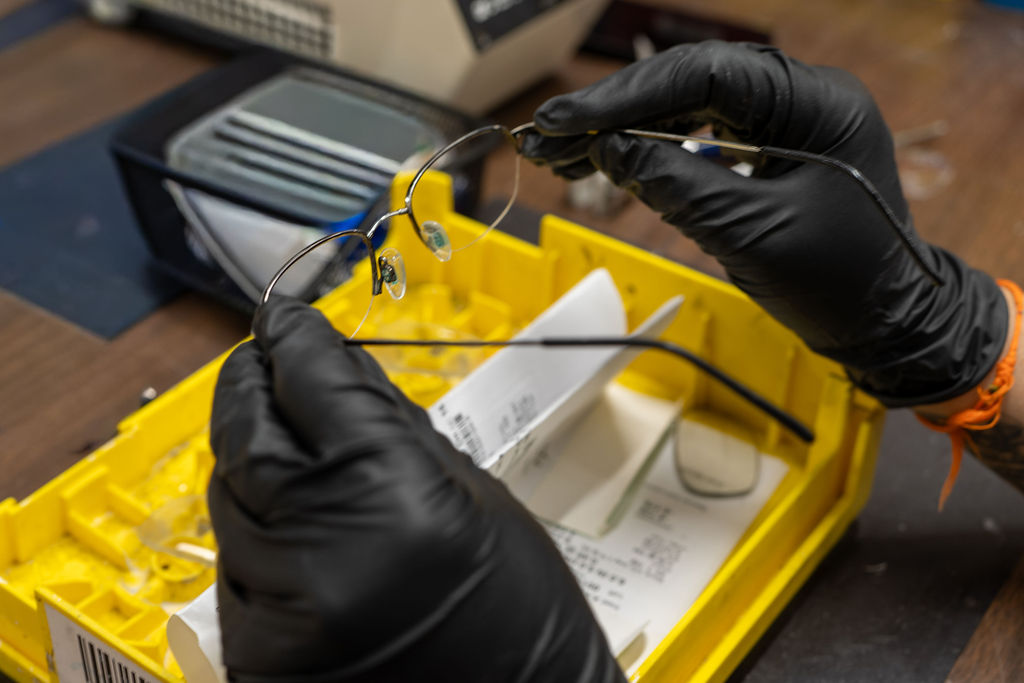 Optician inspecting a finished rimless pair before shipping