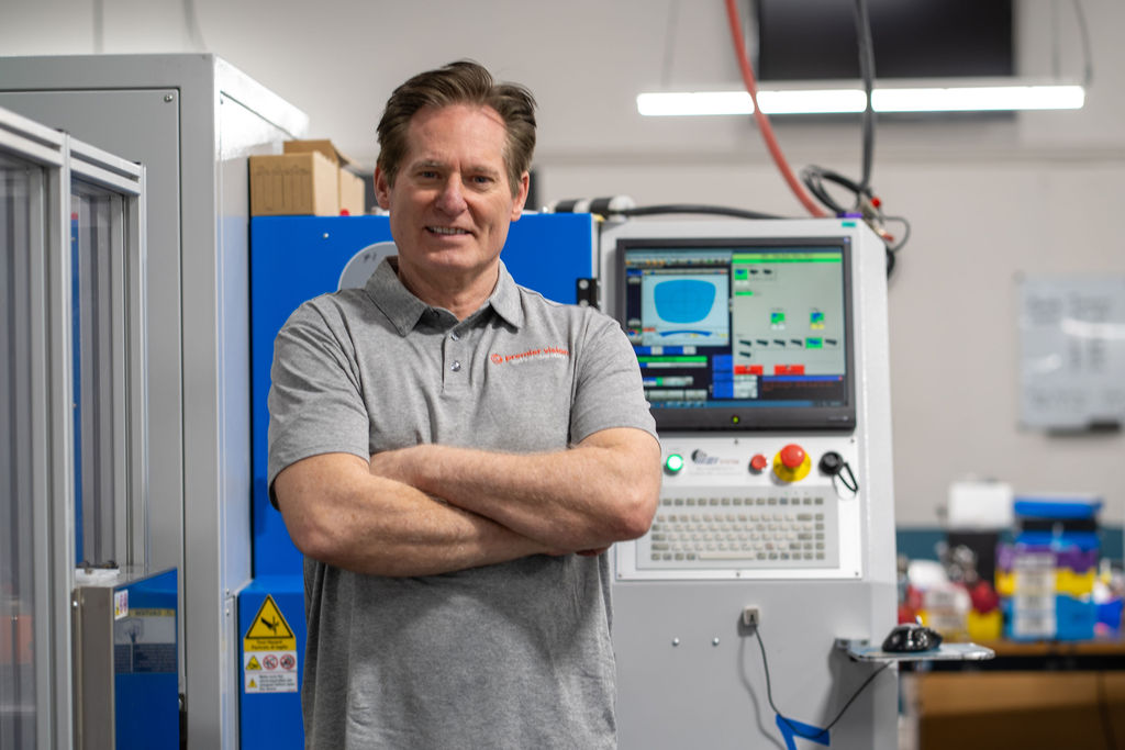 Premier Vision Lab owner in front of an MEI surfacing machine