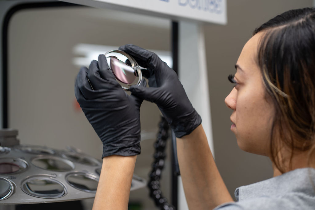 Lab technician inspecting an optical lens
